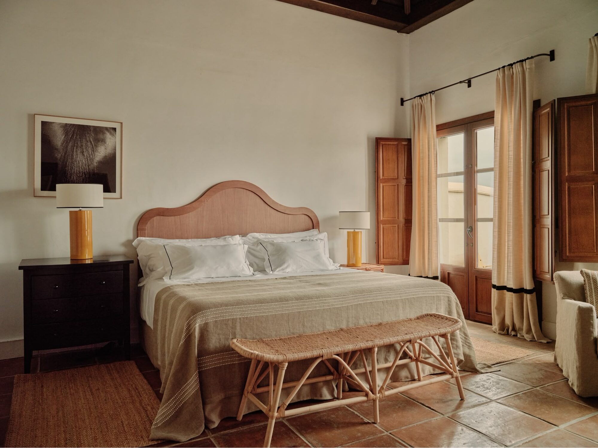 A calm five-star guest room with linen bedding and a rustic timber wardrobe