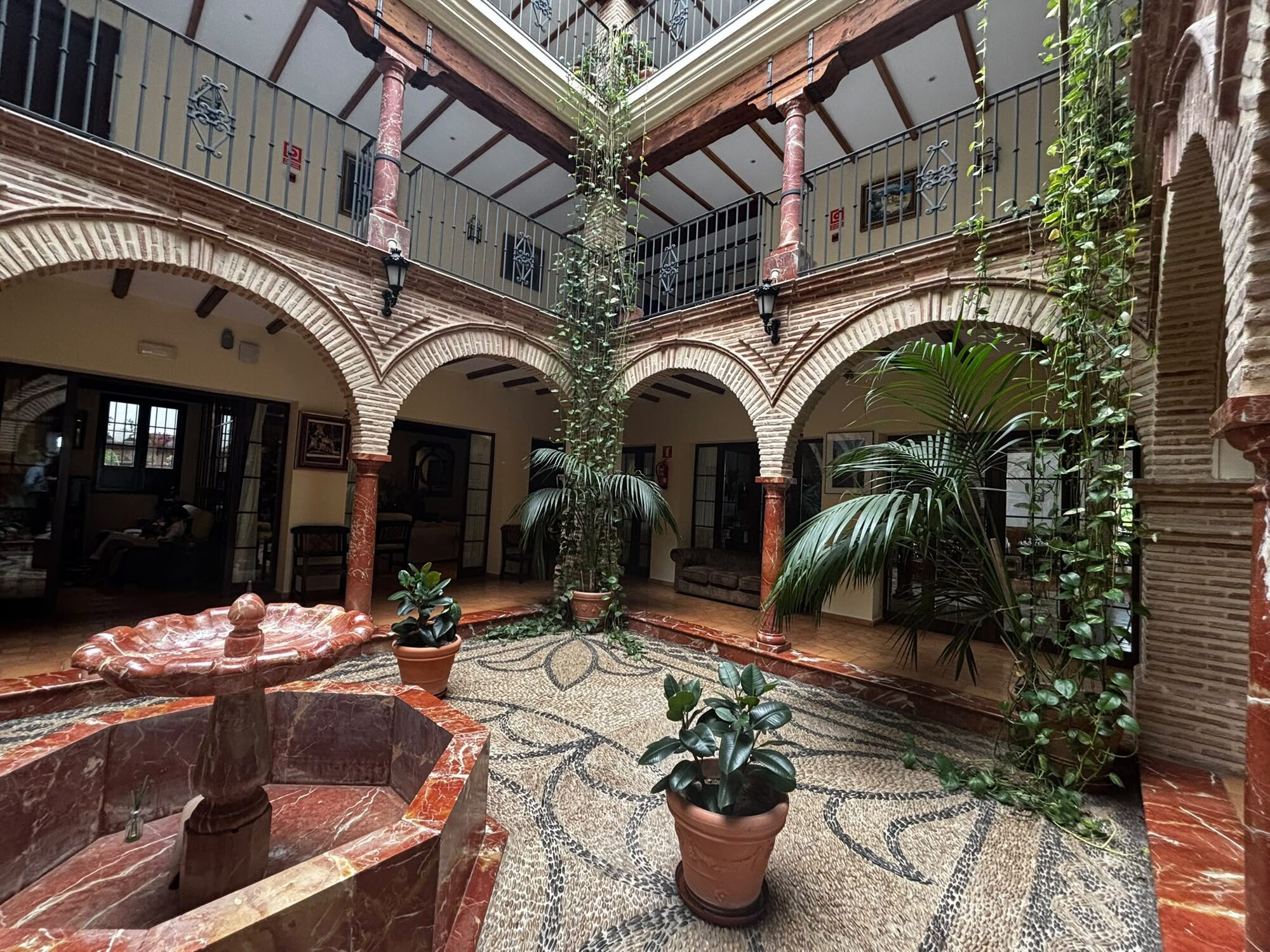 A columned interior courtyard with a marble fountain and mosaic floor at the four-star country hotel