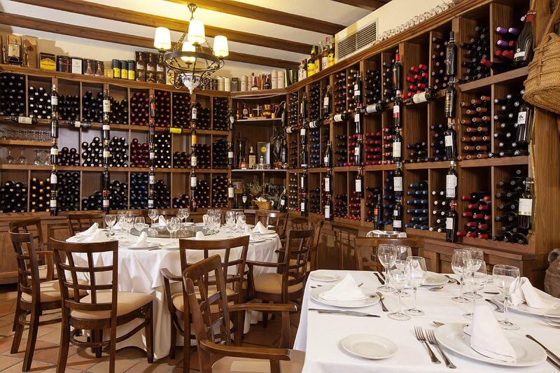 A private dining room lined with wine, tables laid with white linen
